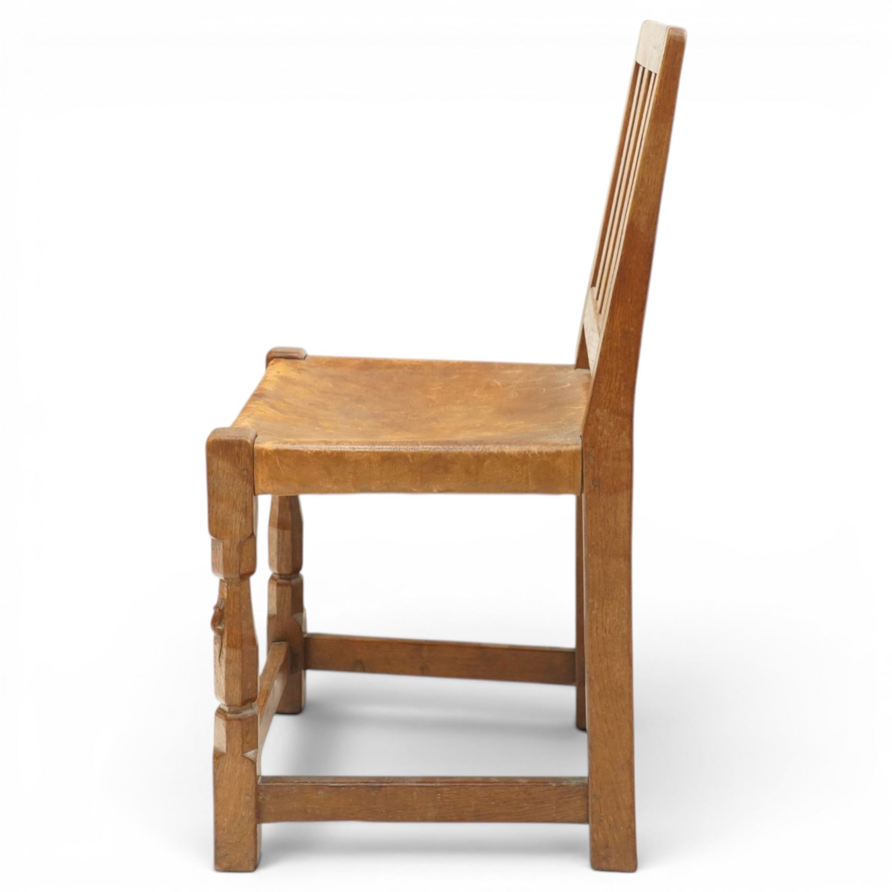 Mouseman - 1940s oak side chair, the slat-back over a slung leather seat, raised on octagonal front supports united by box stretcher, carved with slim mouse signature, by the workshop of Robert Thompson of Kilburn