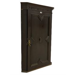 Early 20th century oak corner cupboard, s-scroll carved frieze over single door with geometric mouldings, two interior shelves