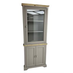 Contemporary teal and oak finish corner cabinet, single glazed door enclosing two shelves, over two panelled cupboard doors