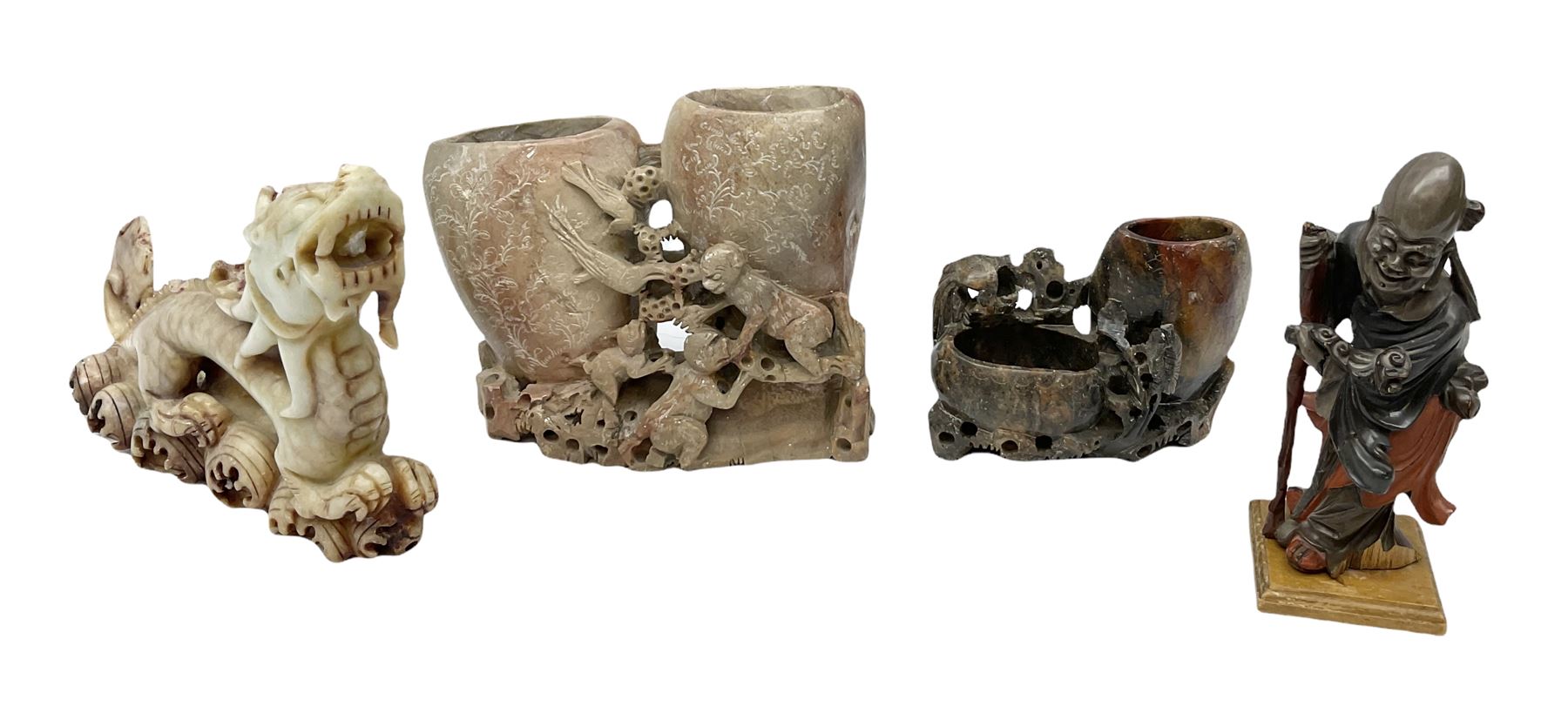 Three soapstone carvings, to include three toed dragon example, carved example with monkeys and another similar, together with carved wood figure, largest L29cm 