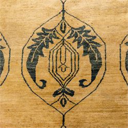 Late 20th century Turkish hand-woven carpet, golden beige field decorated with a repeating lattice of stylized medallions enclosing boteh and angular foliate motifs linked by issuing scrolling vinery within a border of complementary stylized leaf scrolls