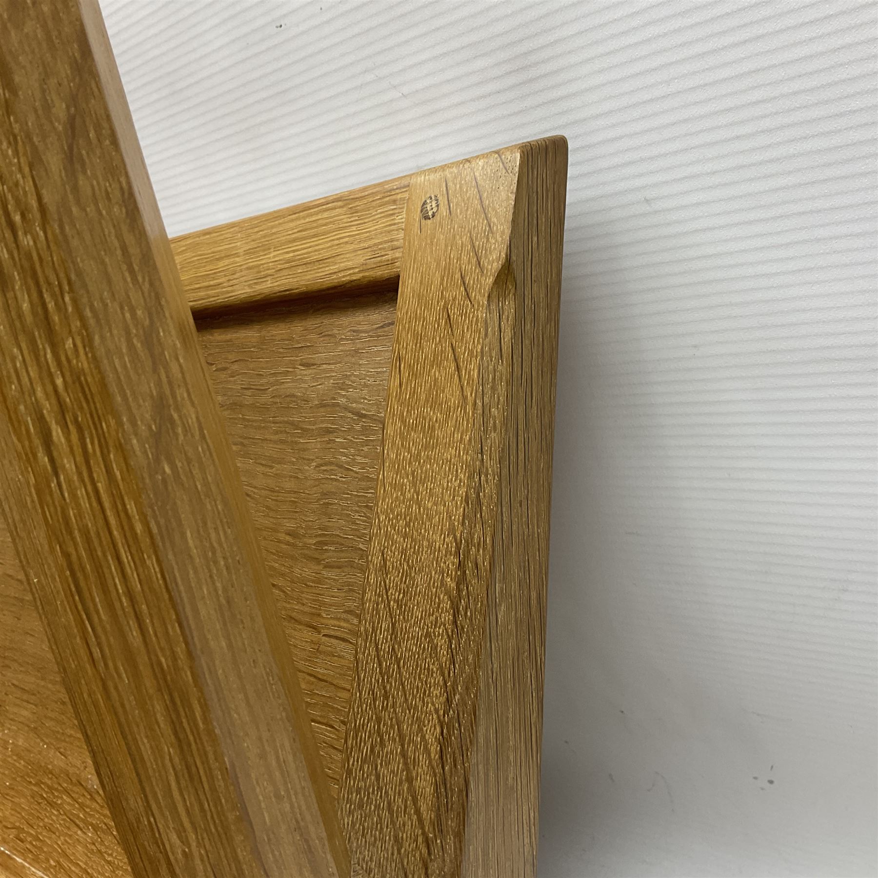 Mouseman - oak magazine rack, the top rail pierced with handle and carved with mouse signature, octagonal supports with two panelled and splayed sides, on sledge feet, by the workshop of Robert Thompson, Kilburn 