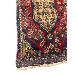 Antique Afghan indigo ground rug, the central pole medallion within a crimson field decorated by foliate motifs (167cm x 84cm); and a Persian crimson ground rug, floral medallion within a lozenge field, guarded border decorated with repeating stylised plant motifs (123cm x 73cm) (2)