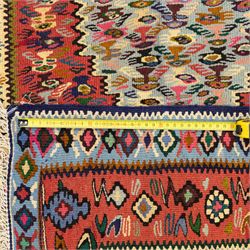 North West Persian Senneh kilim, finely woven wool with elongated central lozenge medallion on a densely patterned field of boteh motifs, in tones of red, ivory, indigo and ochre, framed by floral and diamond guard borders