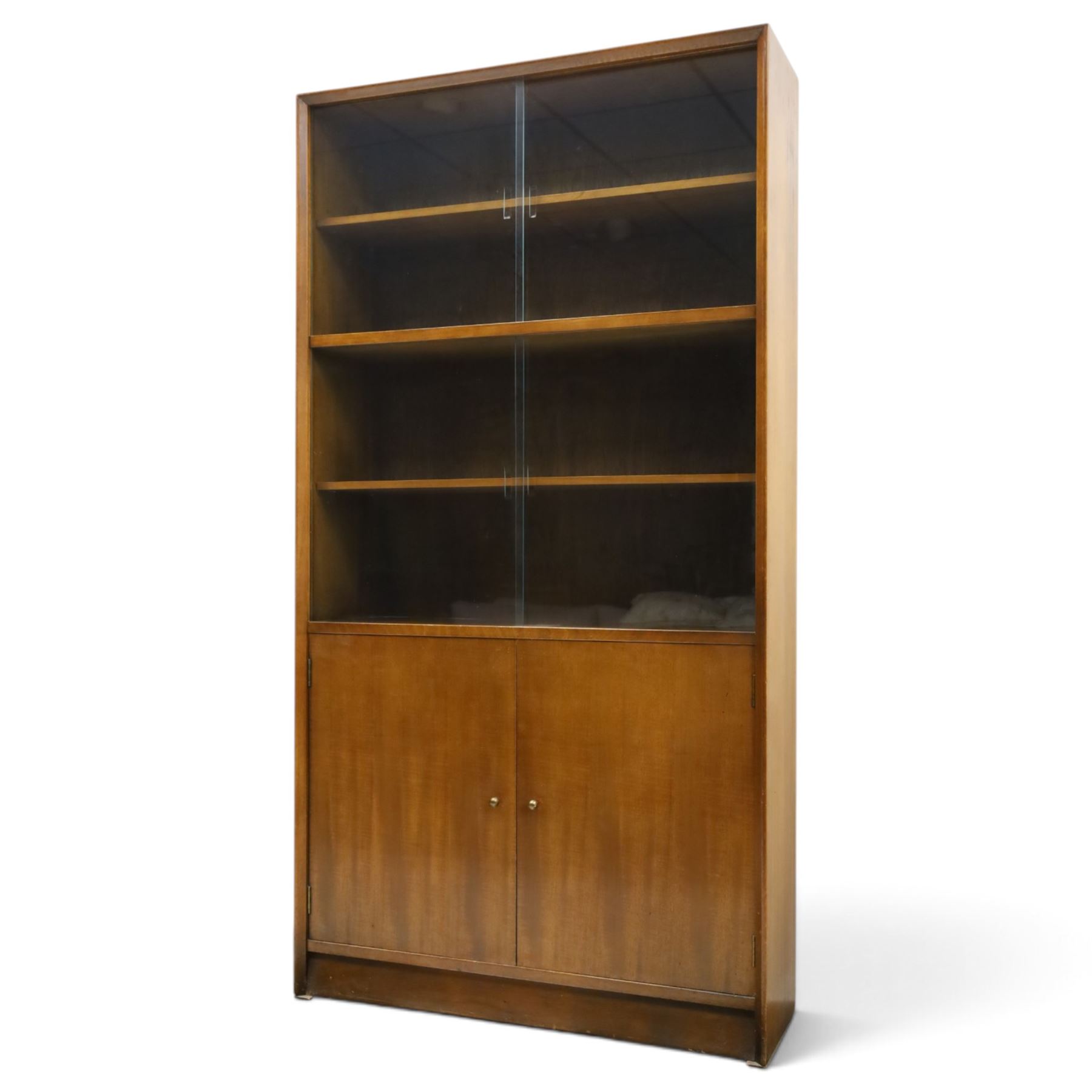 Herbert E Gibbs - Mid 20th century teak glazed bookcase cabinet, rectangular form with two sliding glazed doors enclosing adjustable shelves, lower cupboard enclosed by twin doors and fitted with internal shelf, on plinth base