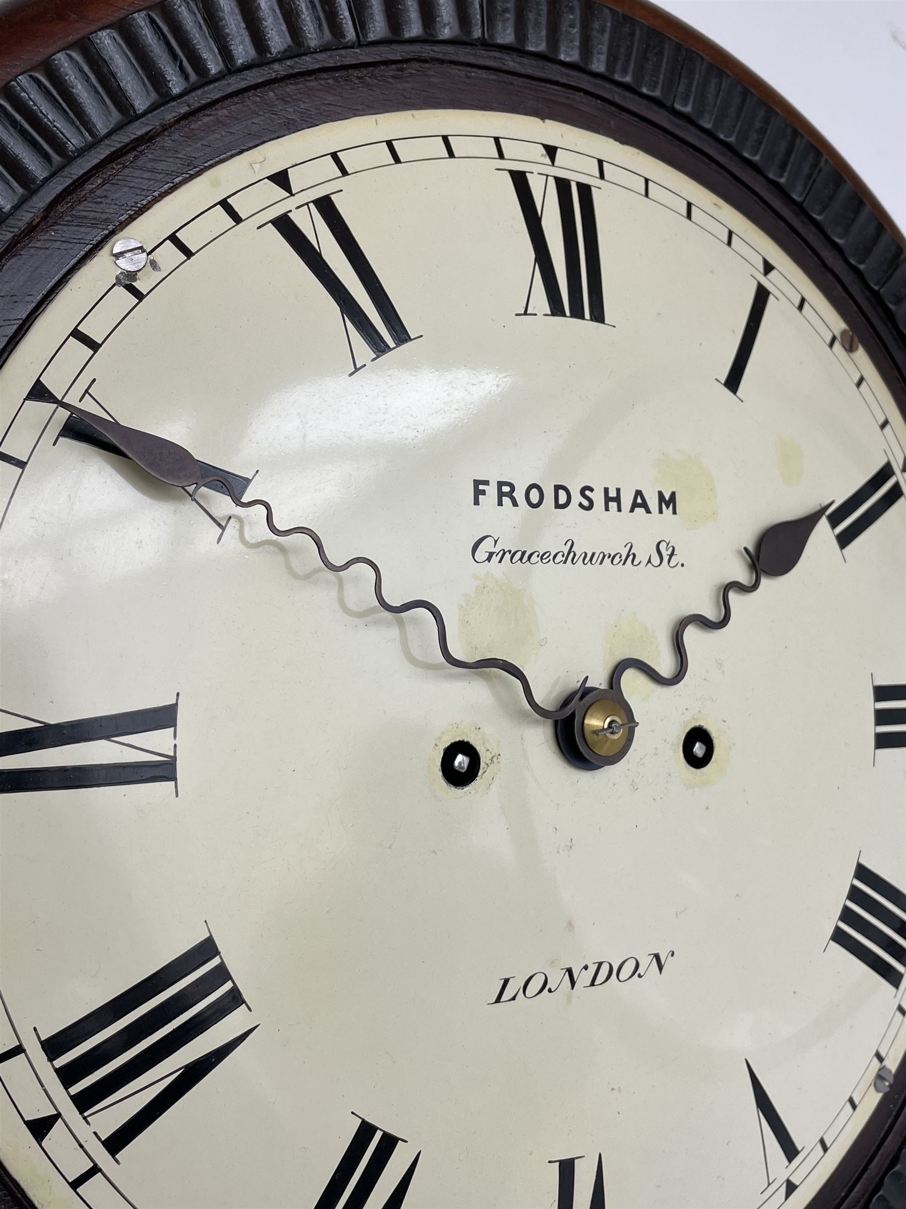 Frodsham of London - 8-day chain driven twin fusee wall clock in a mahogany case c1870, veneered case inlaid with brass stringing and motifs, shaped earpieces and chisel shaped base with pendulum adjustment door, 10” painted steel dial with Roman numerals, minute track and blued serpentine steel hands, dial inscribed Frodsham, Gracechurch Street, London, chain fusee, five-pillar, rack striking movement striking the hours on a cast bell. With pendulum.
H65 W34 D18
George Edward Frodsham, son of John Frodsham is recorded as working in Gracechurch Street, London 1869-79. Succeeded to Frodsham & Baker
