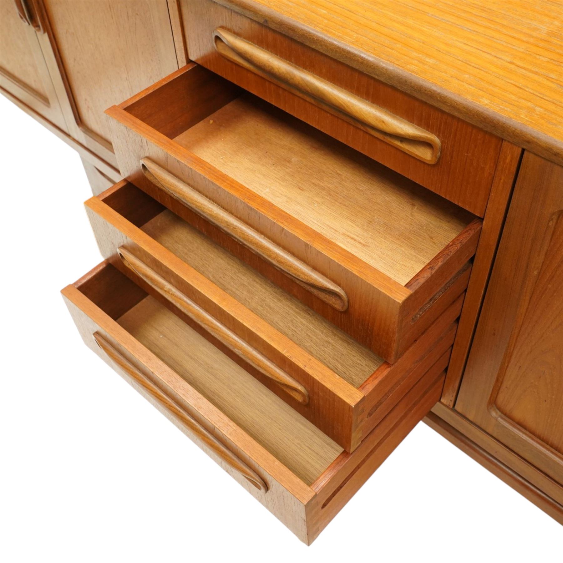 G-Plan - 'Fresco Long John' teak mid 20th century sideboard, a central bank of four drawers, flanked by twin cupboard doors, with recessed handles, on a tapering supports 