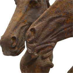 Pair of antique cast iron garden finials or statues of horse heads or busts, the heads with flowing and pierced mane, mounted on spherical finials over square tapering bases