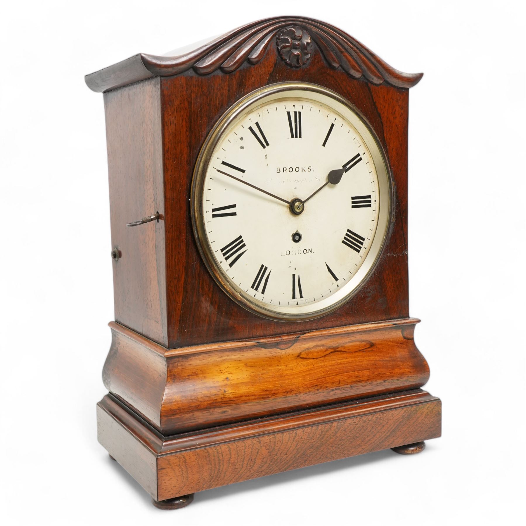 Brooks of London- Regency 8-day rosewood bracket clock c1825, with a serpentine shaped pediment and foliate carving on an ogee stepped base with bun feet, 8