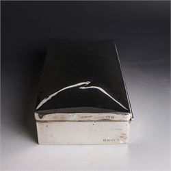 Two silver cigarette boxes, comprising early 20th century plain rectangular example with compartmentalised softwood interior, hallmarked Birmingham 1914, maker's mark indistinct, and an early 20th century example with engine turned decoration and engraved initials to cover, hallmarks worn and indistinct, largest H4.5cm, W21cm