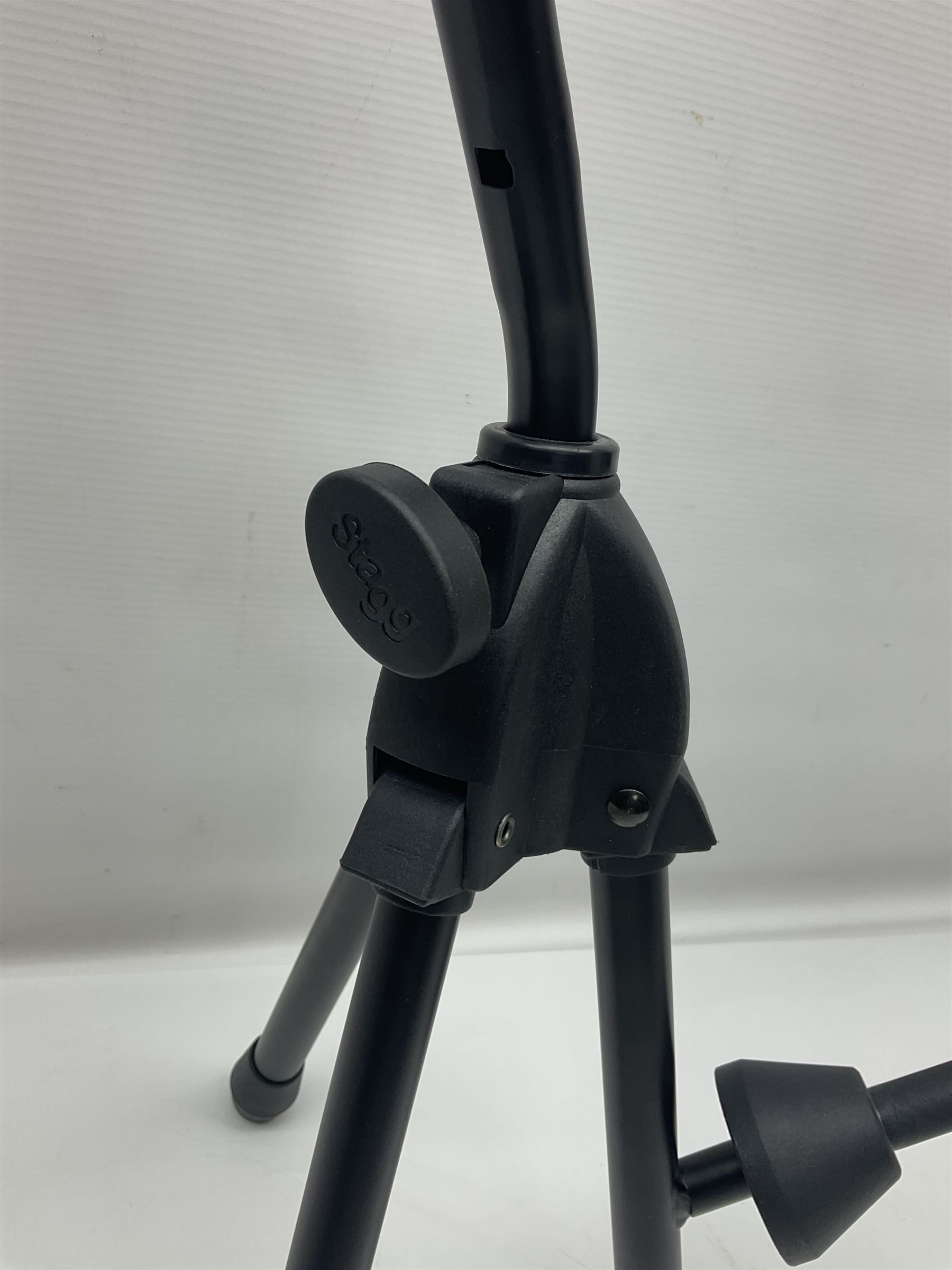 Four folding tubular guitar stands, two by RockJam; and folding tubular saxophone stand (5)