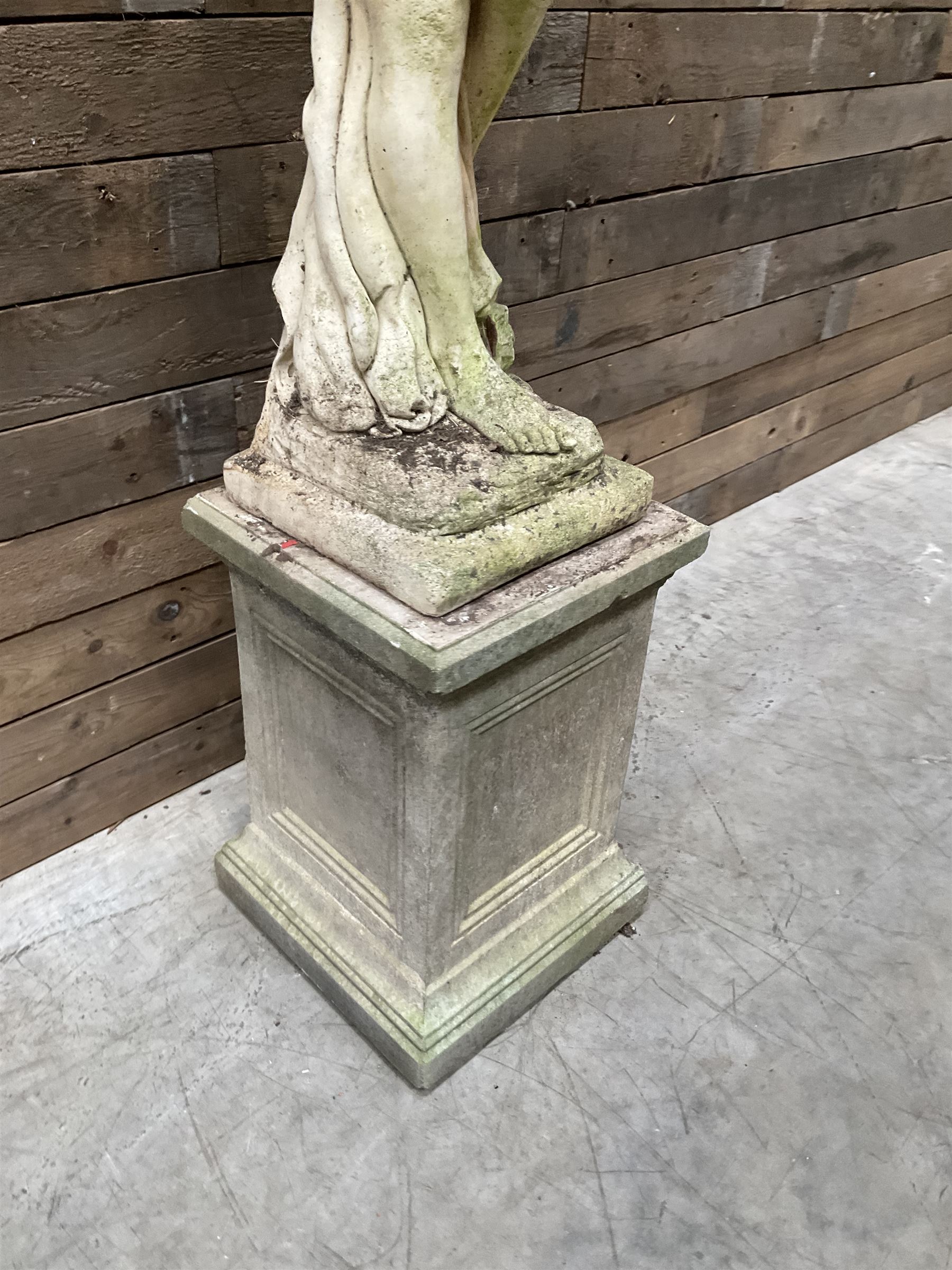 Cast stone garden figure of a bathing lady, raised on square plinth