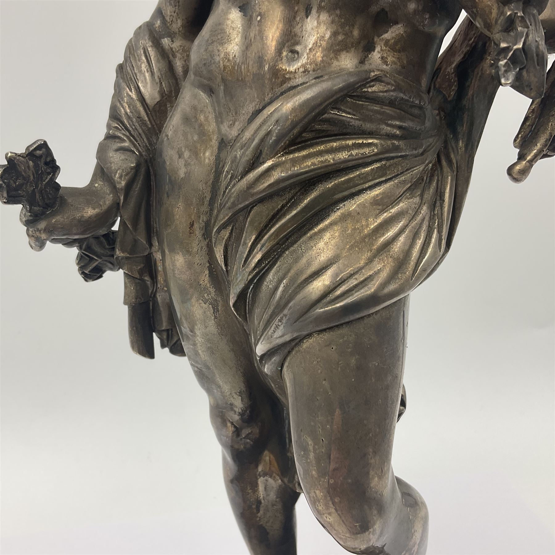 20th century silver plated figure, modelled as a classical male figure, possibly Prometheus, holding flames, one foot resting atop a small dragon, upon a circular spreading base, overall H37.5cm