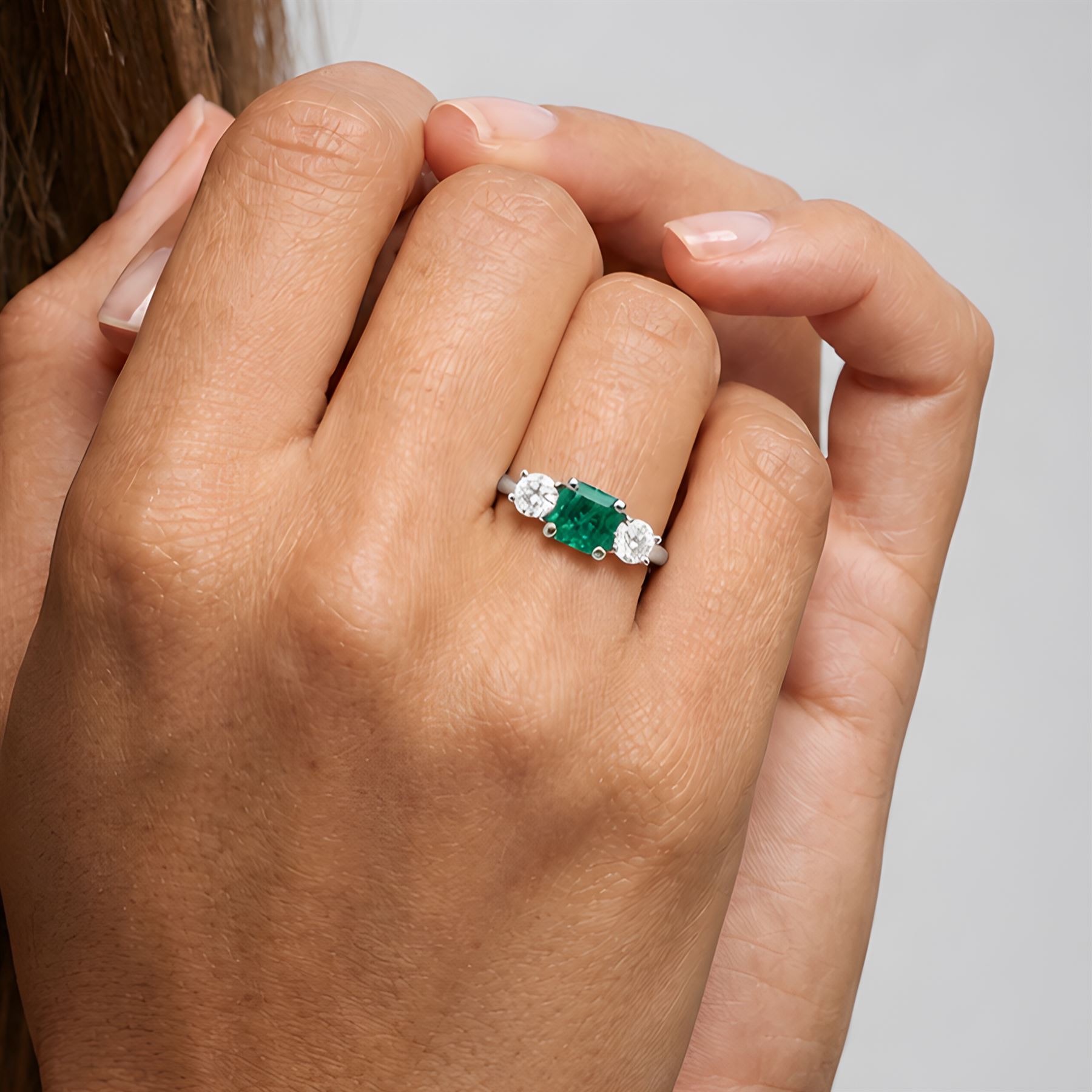 18ct white gold emerald and diamond three stone ring, single modified square cut emerald of approx 0.65 carat, with a round brilliant cut diamond set either side, hallmarked, total diamond weight approx 0.35 carat