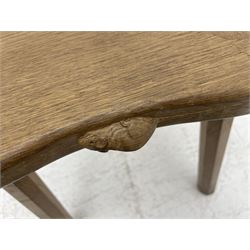 'Mouseman' oak four-legged stool, shaped and dished top carved with mouse signature on four tapered octagonal splayed supports, by Robert Thompson of Kilburn 