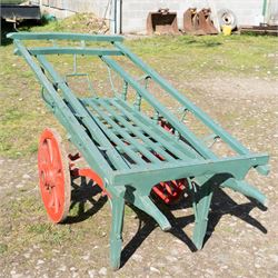 Costermonger’s Cart

A painted costermonger’s cart with green slatted timber body, red painted wooden spoked wheels and red leaf spring suspension. The cart is fitted with raised side rails, turned supports and short projecting handles. Painted lettering is visible along the side rails, together with the number “661” to the frame and wheel rim.
Finished in traditional colours, the cart offers excellent decorative appeal and would be suitable for display, garden or country house settings.

Dimensions:
Overall length: 240 cm
Body length: 215 cm
Width: 94 cm
Height: 86 cm
Wheel diameter: 64 cm

Features:
Timber construction
Open slatted carrying platform
Shaped side rails
Leaf spring suspension
Wooden spoked wheels
Iron tyres
Iron fittings throughout
Carved ownership and maker inscriptions
Traditional painted finish

