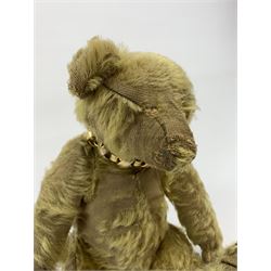 Early 20th century English teddy bear, with wood wool filled body with jointed limbs, felt covered paw pads, five claw stitching to feet and elongated arms with spoon shaped paws H14