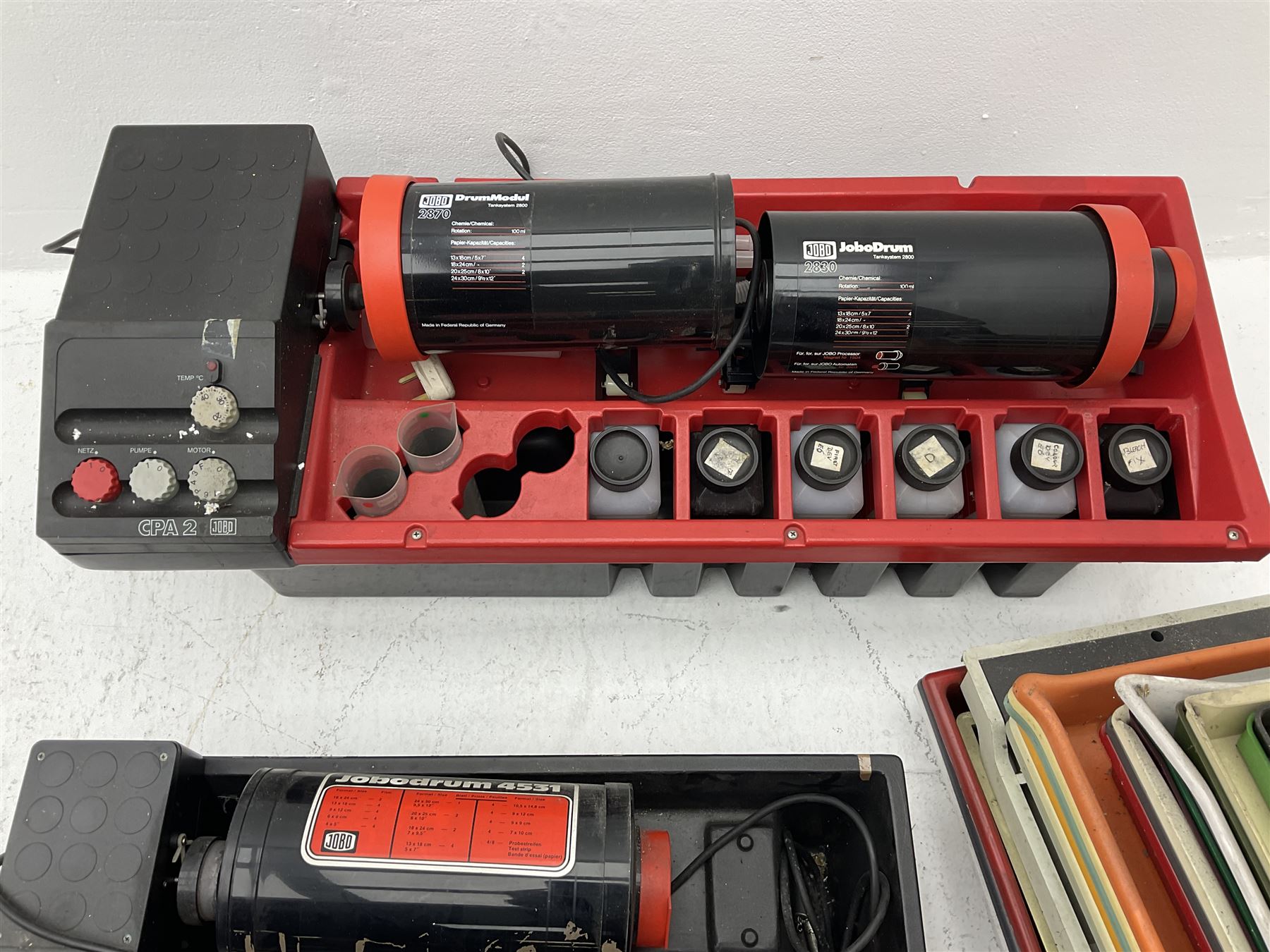 Jobo Colorprocessor CPA 2  fitted with a JoboDrum 2830 drum, DrumModul 2870, three plastic cylinders and six chemistry storage bottles, Jobo Colorprocessor CPA 2, fitted with JoboDrum 4531, four plastic cylinders and 4 chemical storage bottles, and nineteen development trays of various sizes, all untested