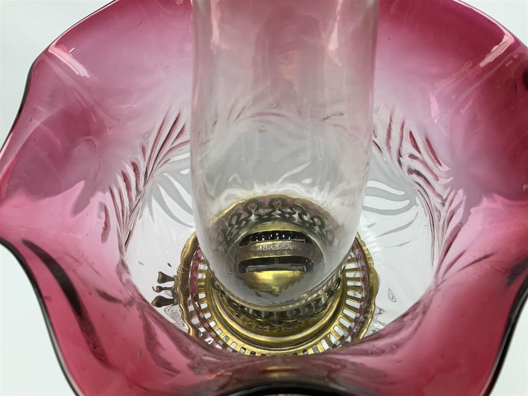 20th century Hawksworth, Eyre & Co silver plated oil lamp, the octagonal stepped base with engraved dedication, leading to an octagonal column supporting a faceted clear glass reservoir, Hinks Duplex burner, clear glass chimney, and cranberry glass shade, overall H71.5cm