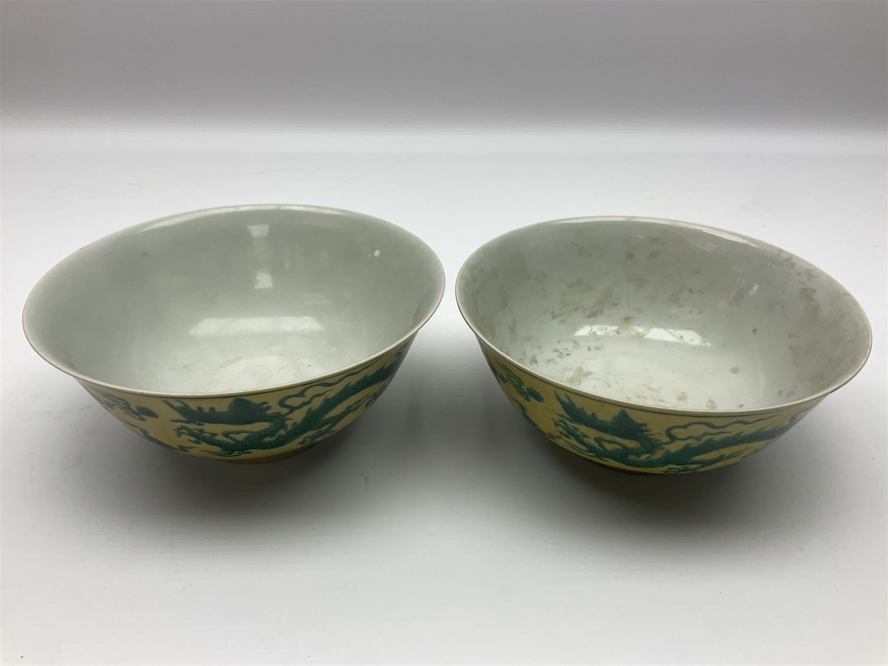 Pair of Chinese famille jaune bowls, decorated in green enamel with a dragon chasing a flaming pearl amongst clouds, upon a yellow ground, the interior decorated to centre with dragon, with six character mark beneath, D17.5cm
