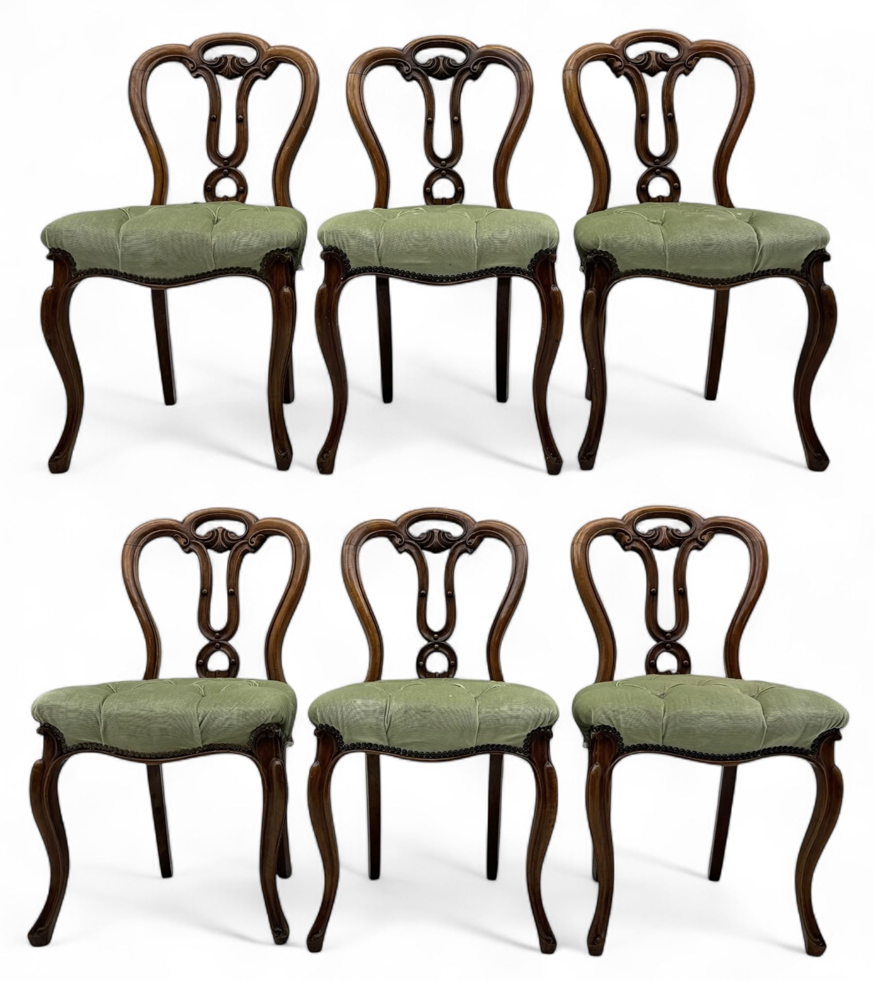 Set of six carved Victorian walnut balloon back dining chairs, button upholstered in green velvet fabric, back with foliate carved decoration supported on scroll form legs 