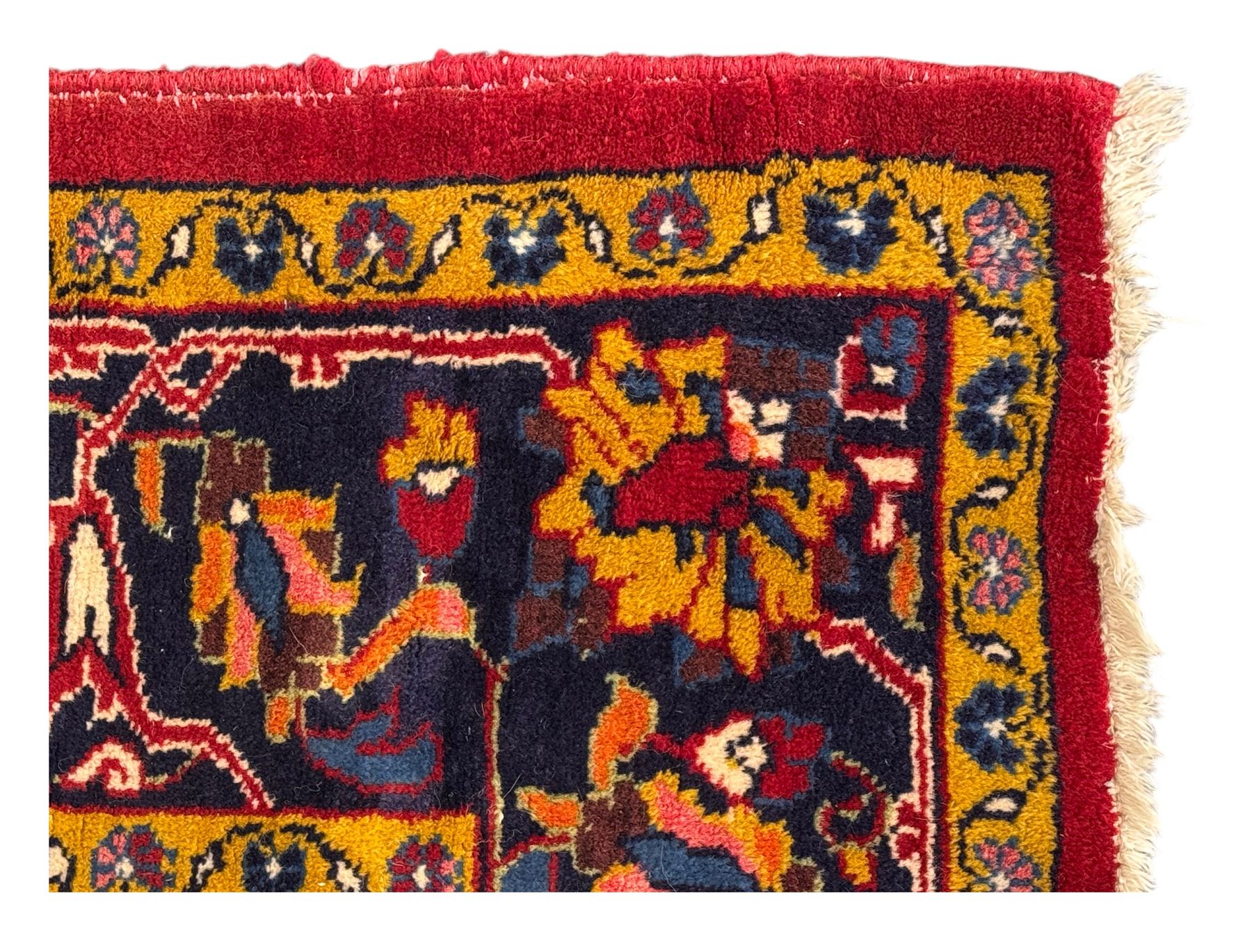 Mid-20th century Persian ground rug, featuring a bold red field and large lobed medallion, flanked by floral corner spandrels, enclosed within multiple borders of stylised vines and palmettes, with fringe to both ends