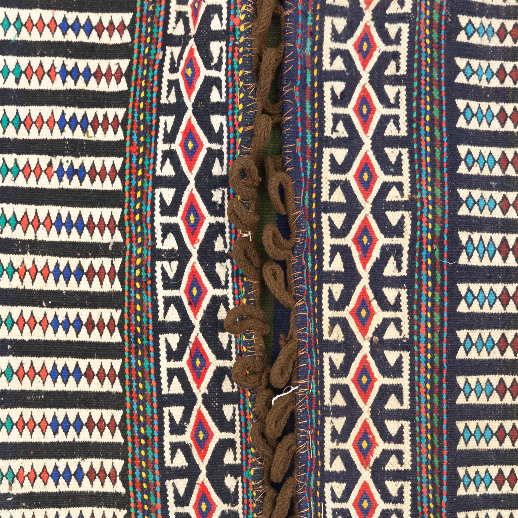 North East Persian Turkoman saddle bag, flatwoven wool with striped field of multicoloured diamond motifs, flanked by geometric borders in crimson and indigo, joined at centre with original braided fastening