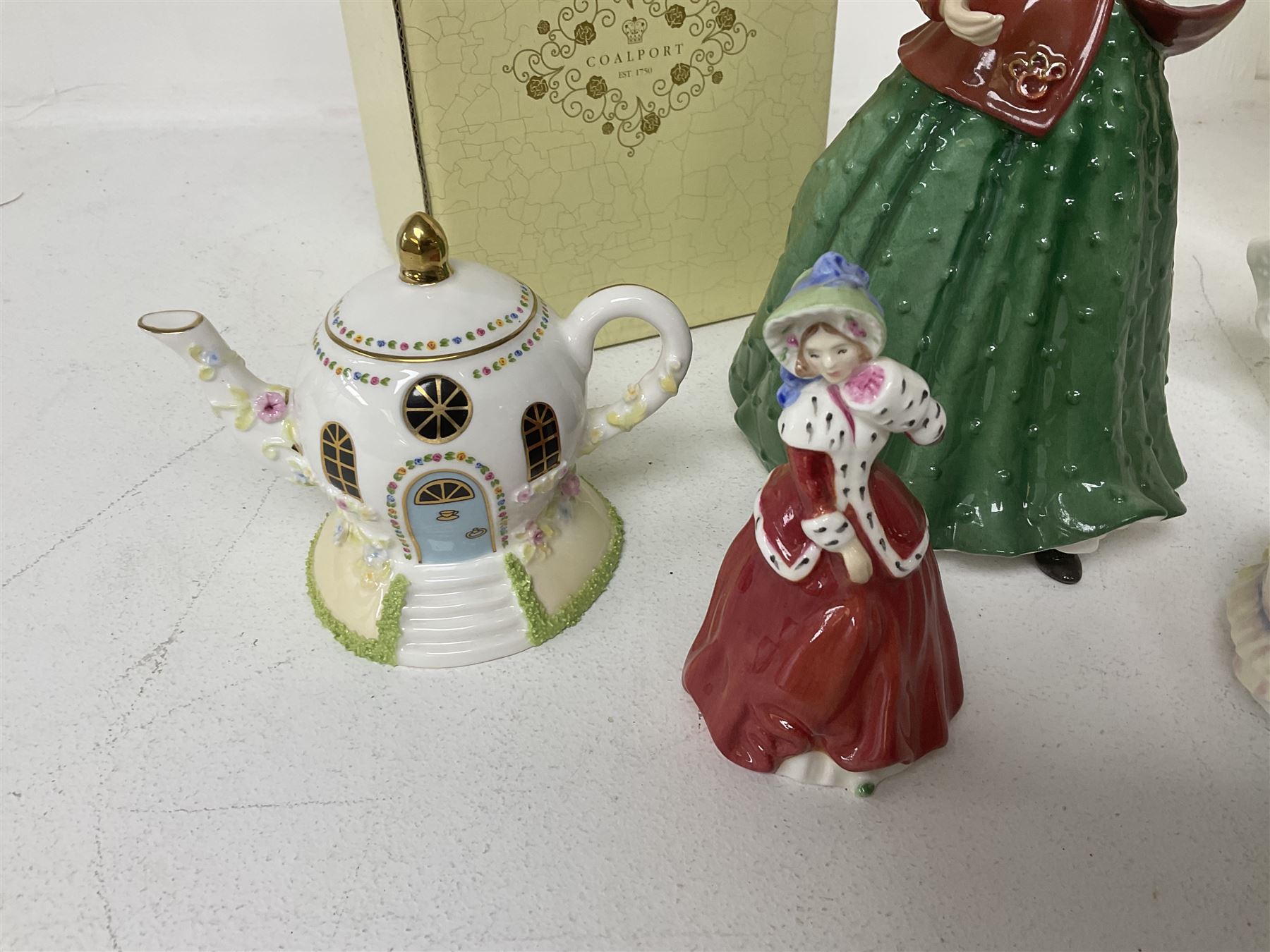Two Coalport cottages, comprising Teapot cottage and Easter Cottage, together with four Royal Doulton figures, including Holly and Friendship 
