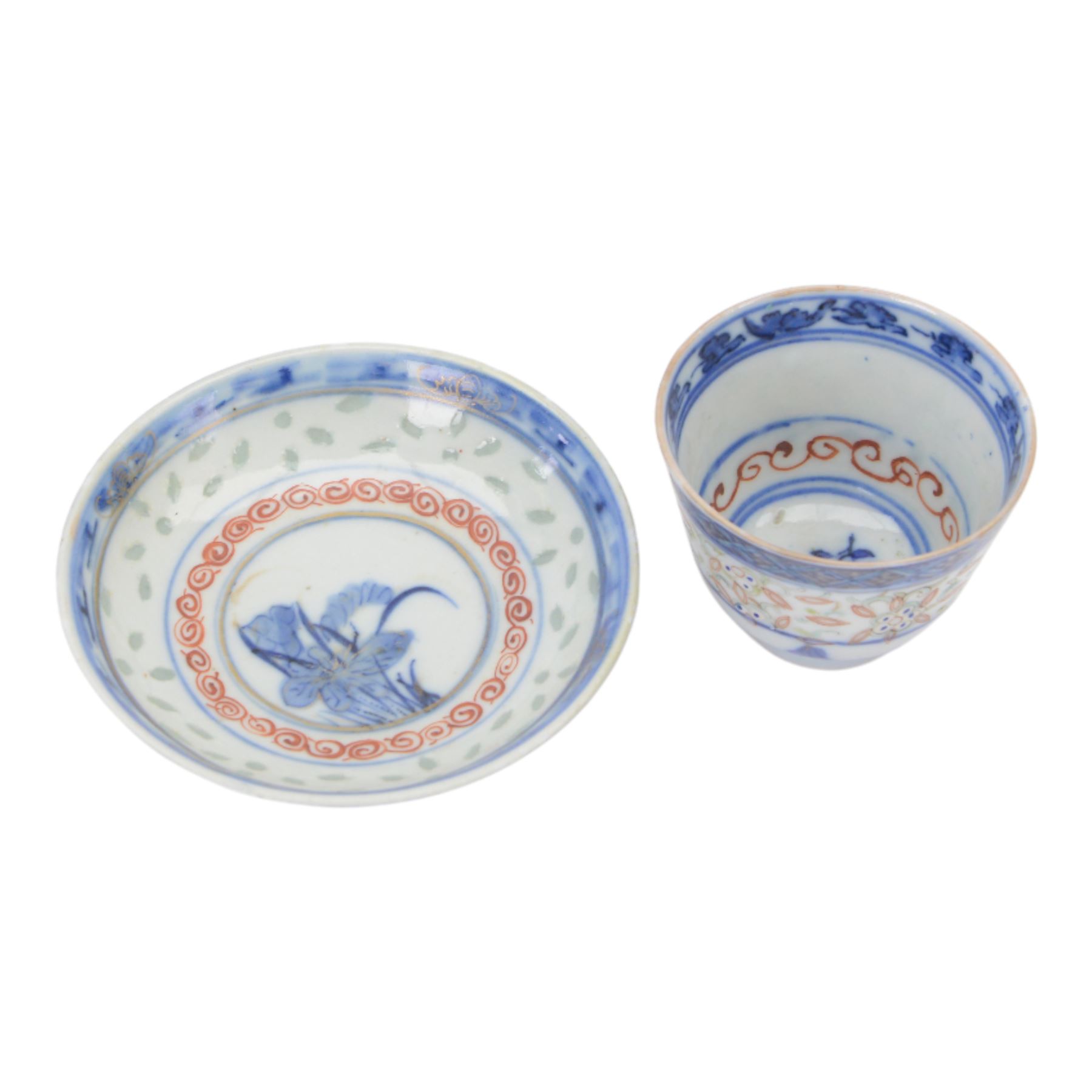 Chinese late Qing Dynasty Guangxu period rice grain detailed teabowl and saucer, each decorated in underglaze blue with flowers and foliate borders, and further detailed with iron red and pale green band of flower heads, and scrolling bands, teabowl with apocryphal Kangxi mark beneath and saucer with apocryphal Qianlong mark beneath, teabowl H5cm, saucer D10cm
