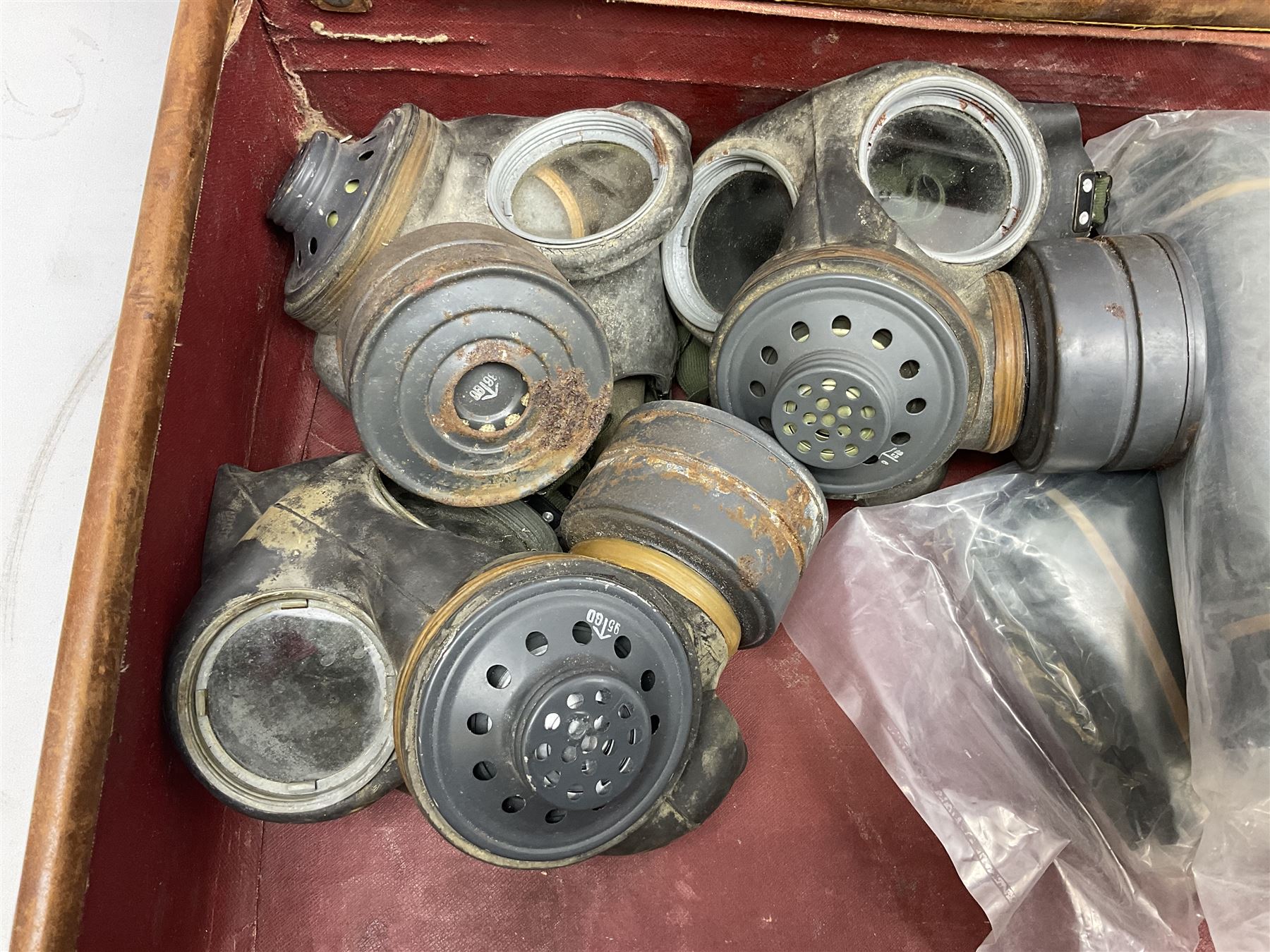 Early 20th century leather suitcase marked to the top 'Major P.M. Newton R.E. Crossways, Bridlington, East Yorkshire' 60 x 40cm; another similar leather suitcase marked W.D. to the lid; three post-WW2 respirators; and three unopened pairs of British Army N.B.C. (Nuclear Biological Chemical) No.1 Mk.III Trousers Protective (8)