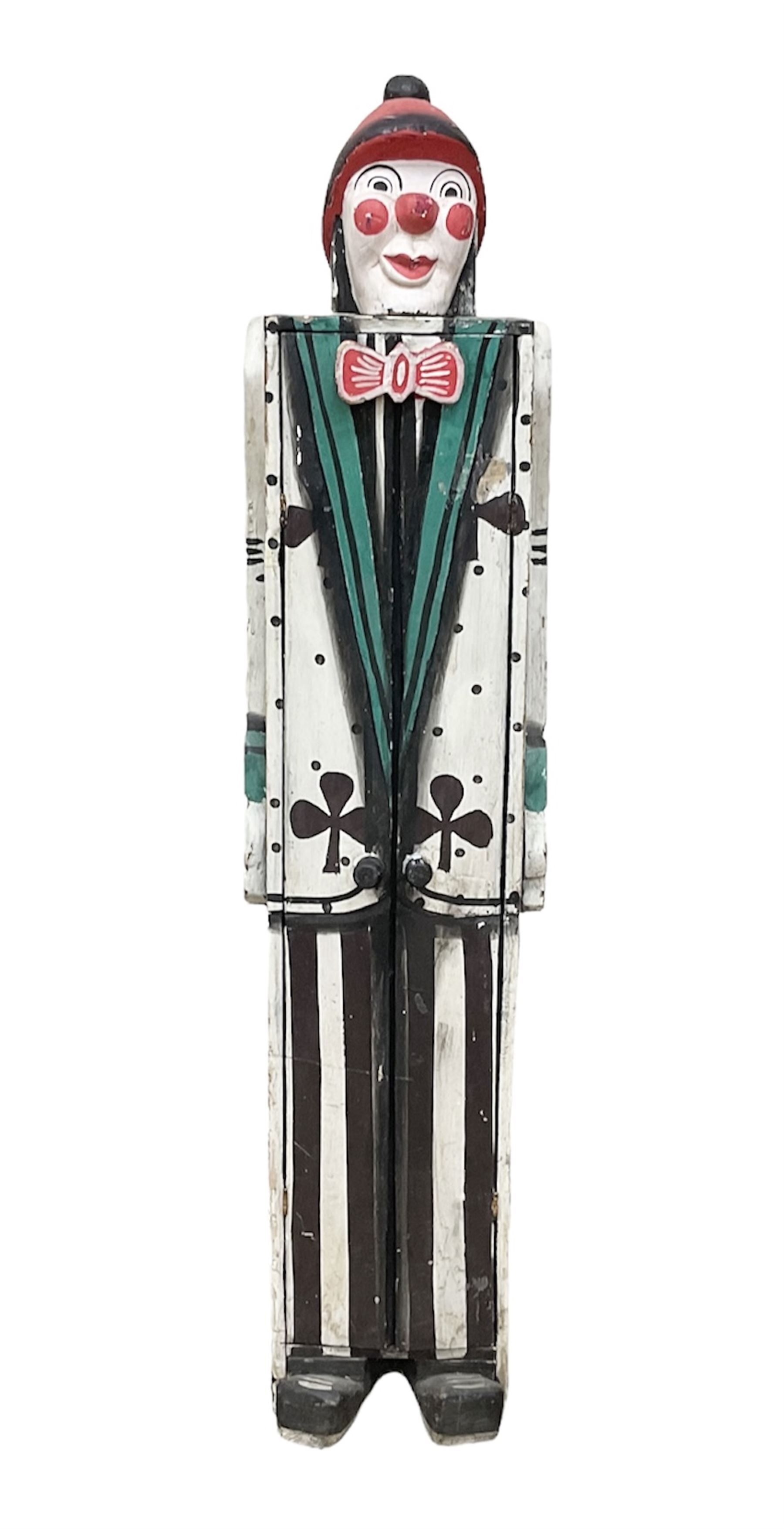 Folk art circus clown cabinet, the the two hinged doors with bow tie decoration opening to reveal fitted shelved interior, the body painted with polka dots and spades, H121cm