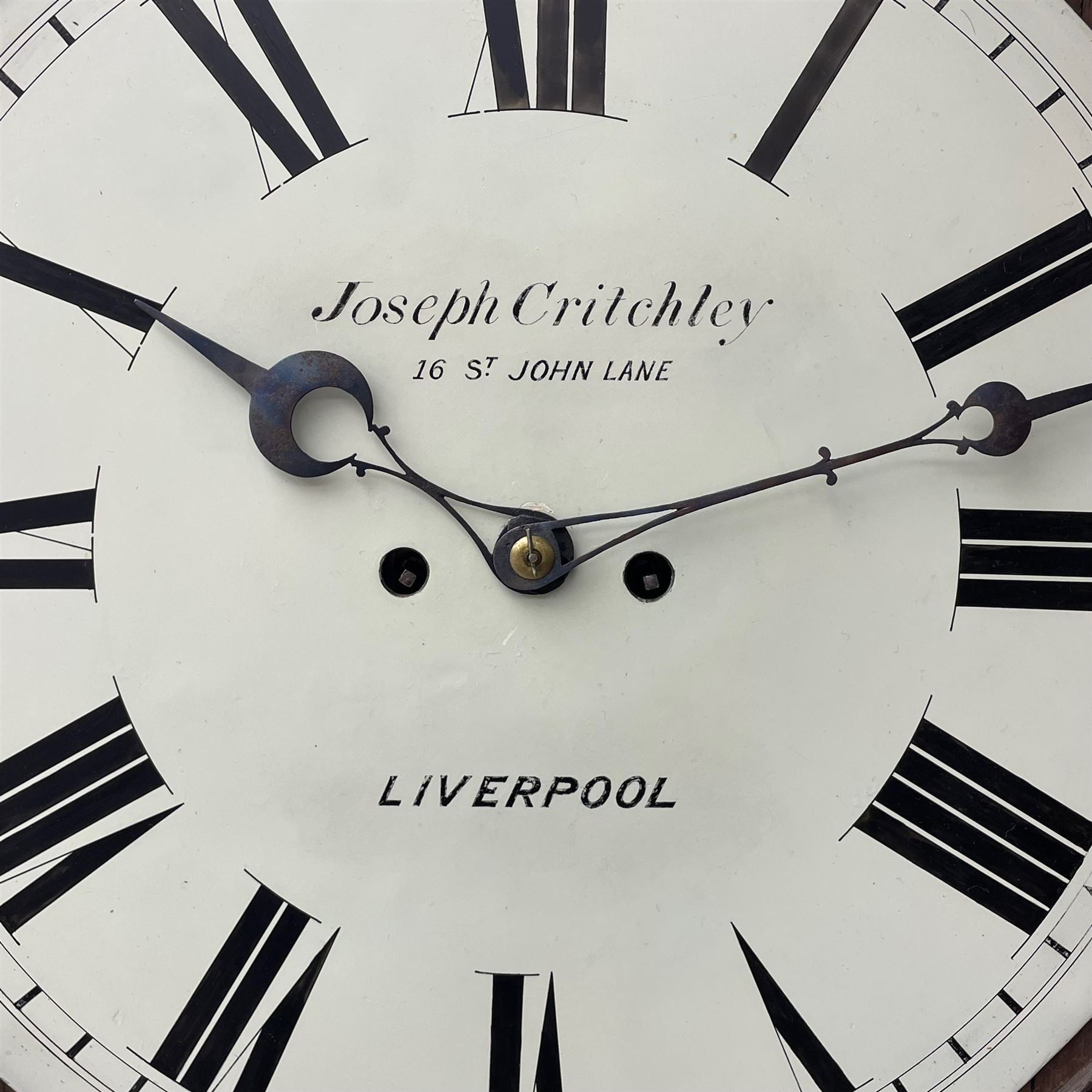 Joseph Critchley of Liverpool -  early 19th century twin fusee 8-day rosewood and mother of pearl inlaid drop-dial wall clock c1820, inlaid circular wooden dial surround with carved ears representing grapes and vine leaves, glazed box with a scroll carved surround, curved base and pendulum adjustment door, 14” painted dial with Roman numerals, minute track, and pierced steel hands within a cast brass bezel and flat glass, dial pinned to a four pillar chain driven fusee movement striking the hours on a bell. With pendulum and key.