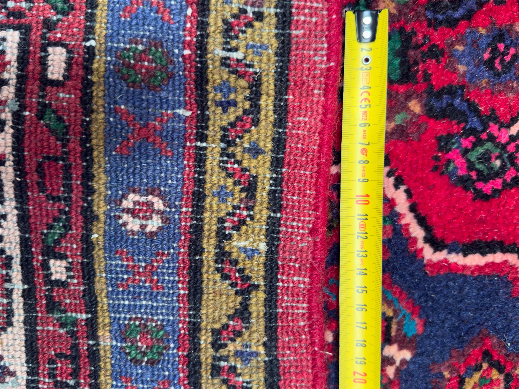 Northwestern Persian Hamadan hand-knotted rug, madder red field with a lozenge medallion enclosing an ivory centrepiece, indigo spandrels within an ivory border of stylized floral motifs between multiple guard borders 