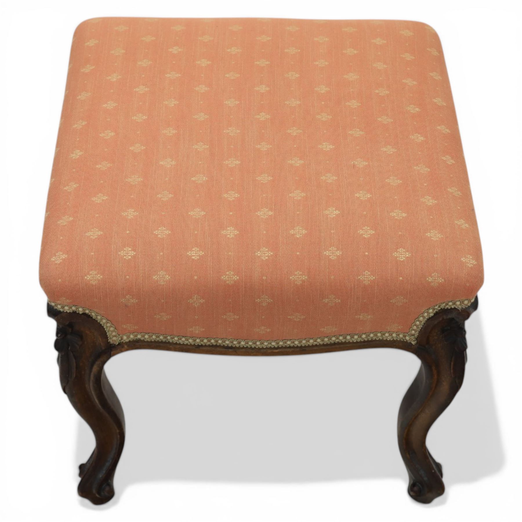 19th century mahogany framed footstool on floral carved cabriole supports upholstered in coral fabric
