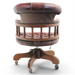 Captains swivel desk chair upholstered in oxblood leather, buttoned back and seat, shaped arm bow raised on turned spindles, five spoke base raised on castors
