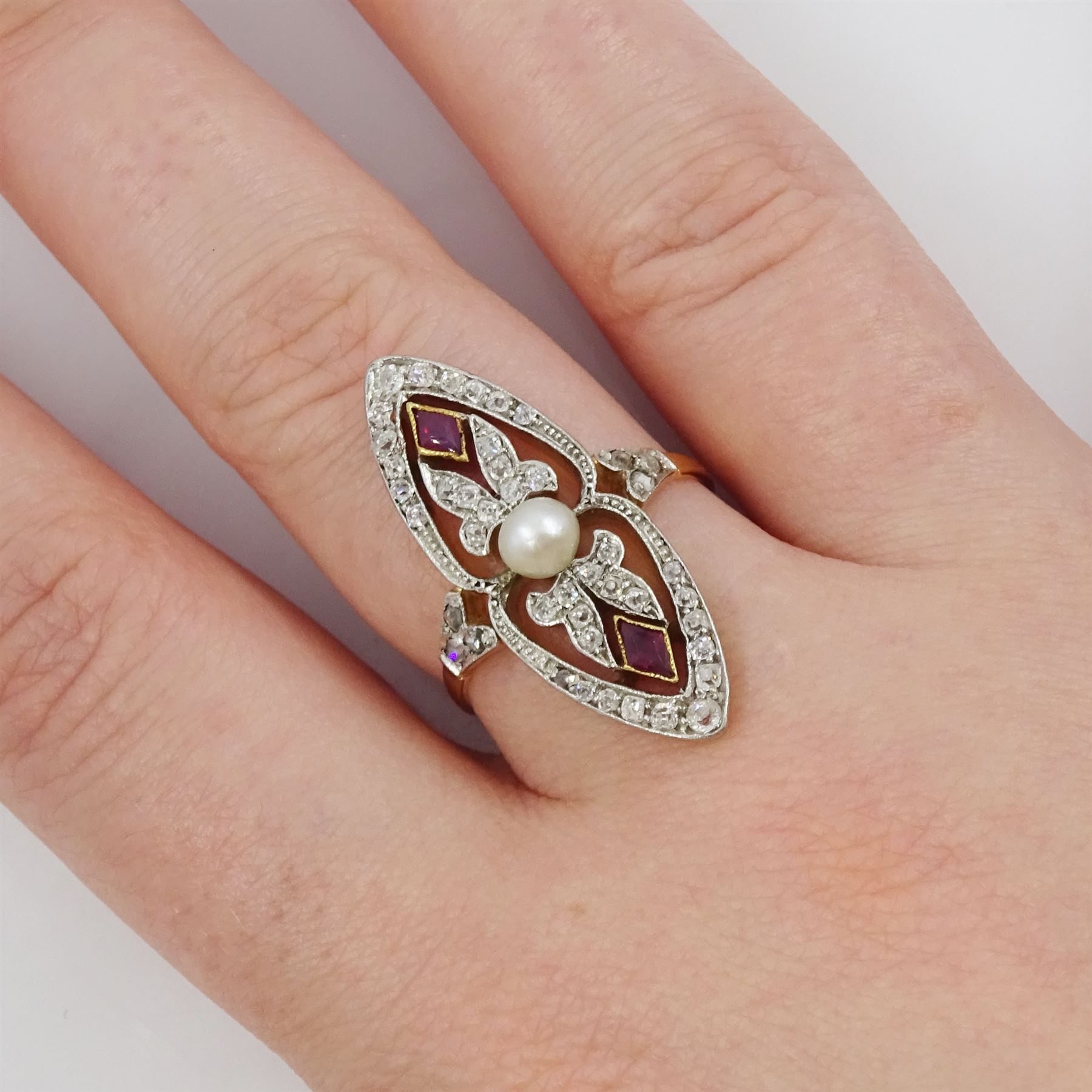 Early 20th century gold and platinum diamond, ruby and pearl marquise shaped ring, set with a single white pearl, within a fancy openwork old cut diamond and kite cut ruby surround, with diamond set shoulders, total diamond weight approx 0.50 carat