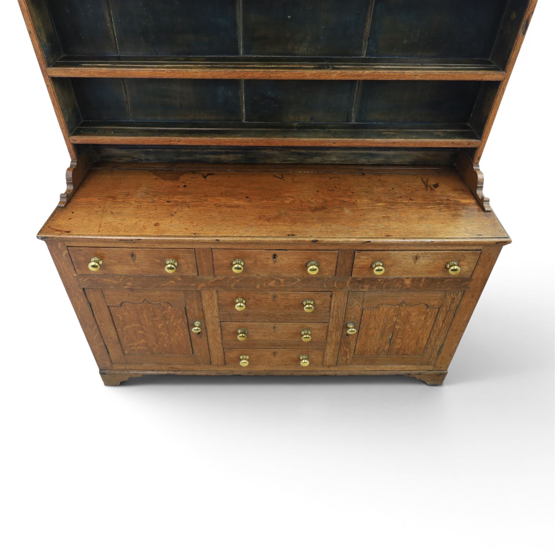 18th century Georgian oak dresser and rack, three back-boarded plate shelves, above six drawers and two cupboards, raised on bracket feet