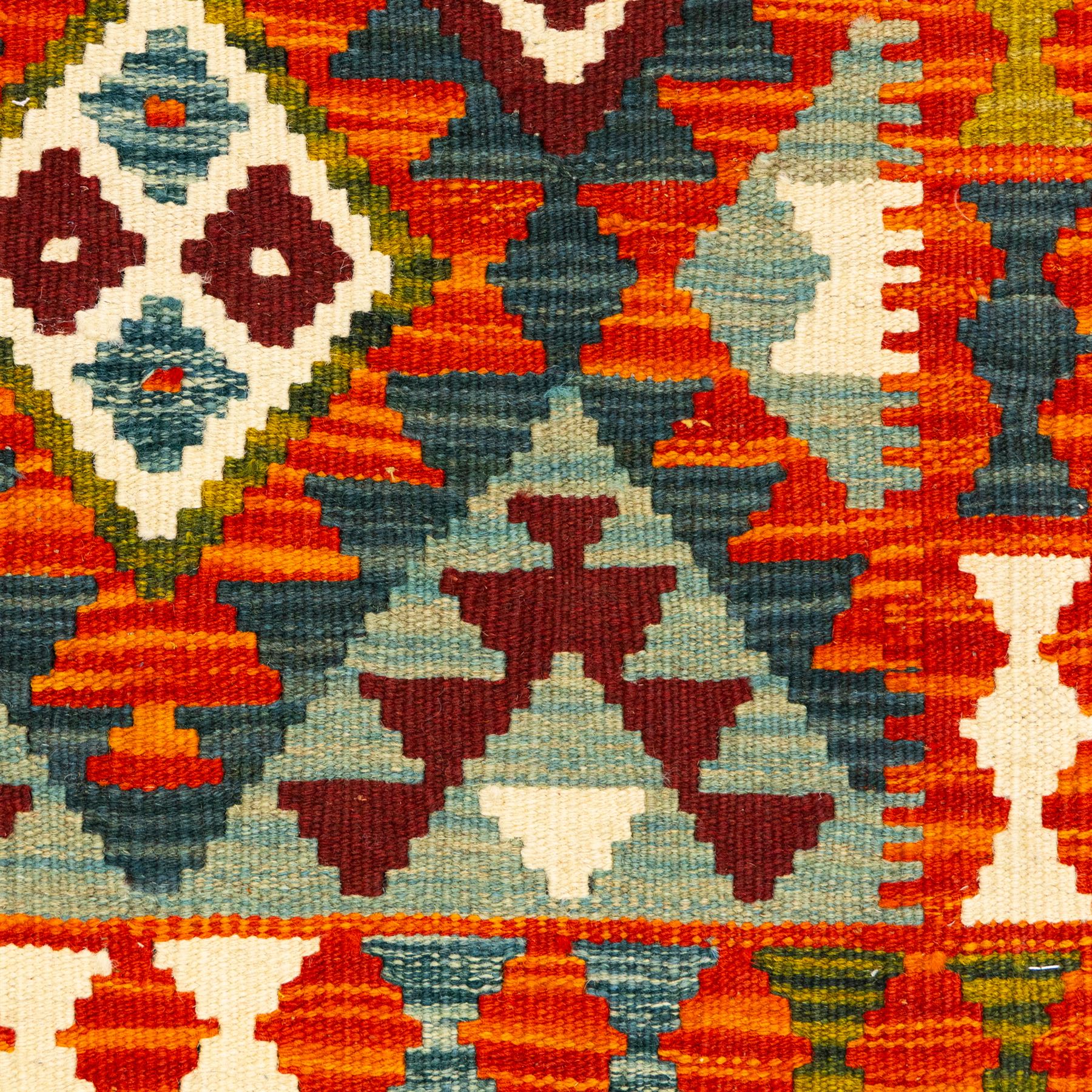 Afghan Maimana kilim flatweave runner, central field features a large bold nested diamond motifs and stylized geometric lozenge patterns on crimson, olive purple, blue, and green tone ground, border stripe in teal ground, and fringe