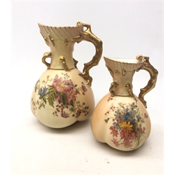  Large Royal Worcester blush ivory jug, of baluster form with naturalist modelled handle, hand painted with flowers and heightened with gilt, H21cm. Together with a similar smaller example, H15.5cm, each with red printed marks beneath, Rd No 167140, shape 1507.   