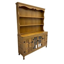 Yorkshire oak - adzed oak dresser, the rack with projecting cornice over shaped frieze and two shelves, the dresser fitted with central glazed double cupboard flanked by two panelled single cupboards, panelled sides