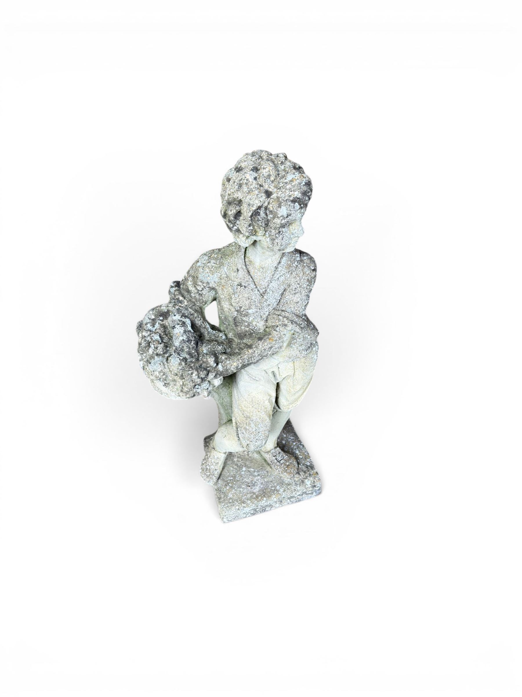 Weathered cast stone garden figure depicting a child holding a fruit basket