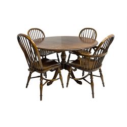 Figured oak dining table, circular moulded top on turned pedestal with four splayed supports with spade feet, together with four Windsor chairs, two armchairs and two sidechairs, all on turned supports with crinoline stretchers