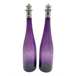  Pair of Victorian amethyst glass decanters, each of slender bottle form, with silver collars and stoppers, hallmarked Henry Manton, Birmingham 1840, H35cm