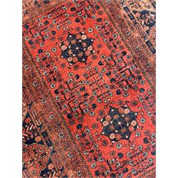 Small Afghan red and indigo rug, the main field decorated with stars and stylised plant motifs, the border bands decorated with geometric motifs