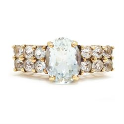 9ct gold aquamarine and blue topaz ring, single oval cut aquamarine, with two rows of roun...