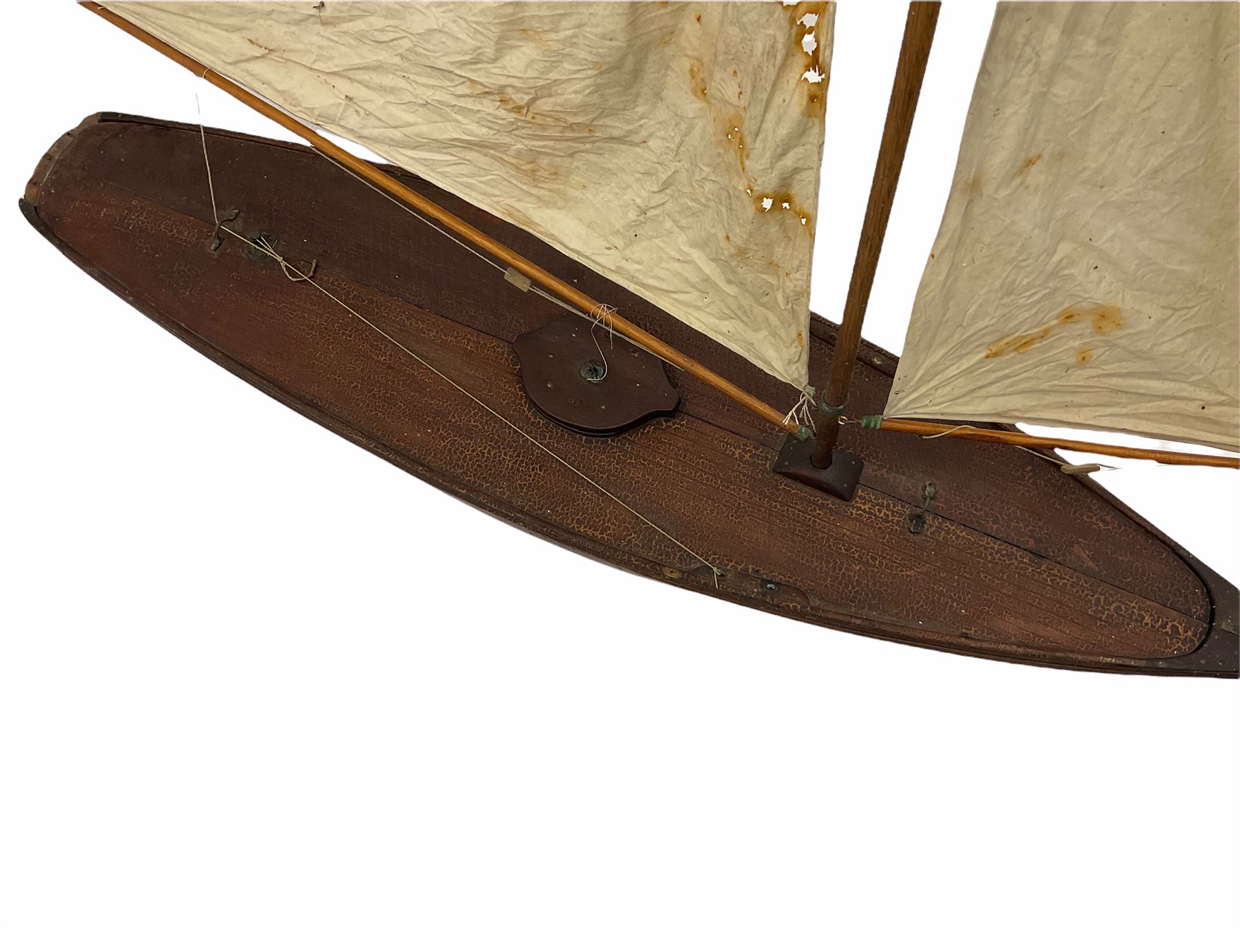 Large Victorian pond yacht, the planked hardwood hull with large lead weighted keel and working rudder, simulated planked deck and single mast with original sails; on later scratch-built wooden stand L117cm H151cm
