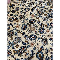 Persian Kashan ivory ground rug, the field decorated with stylised plant motifs and interlacing leafy branches, scrolling border decorated with further plant motifs, floral design guard bands  