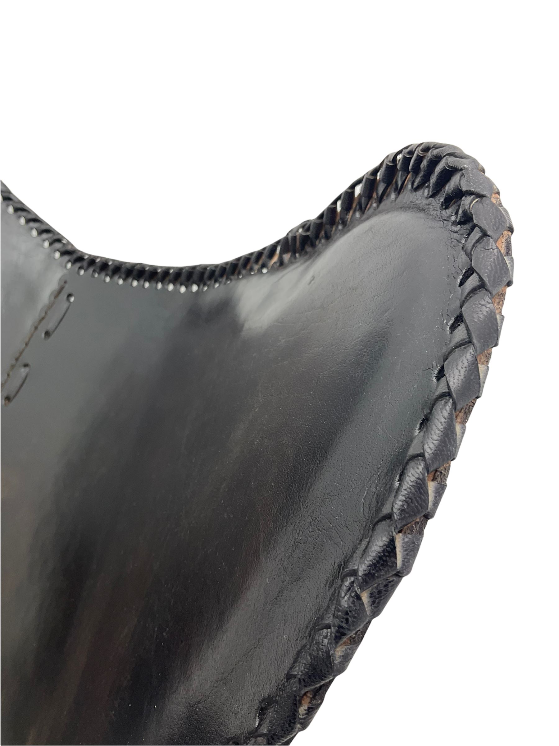 Metal framed butterfly chair upholstered in slung dark tan stitched leather 