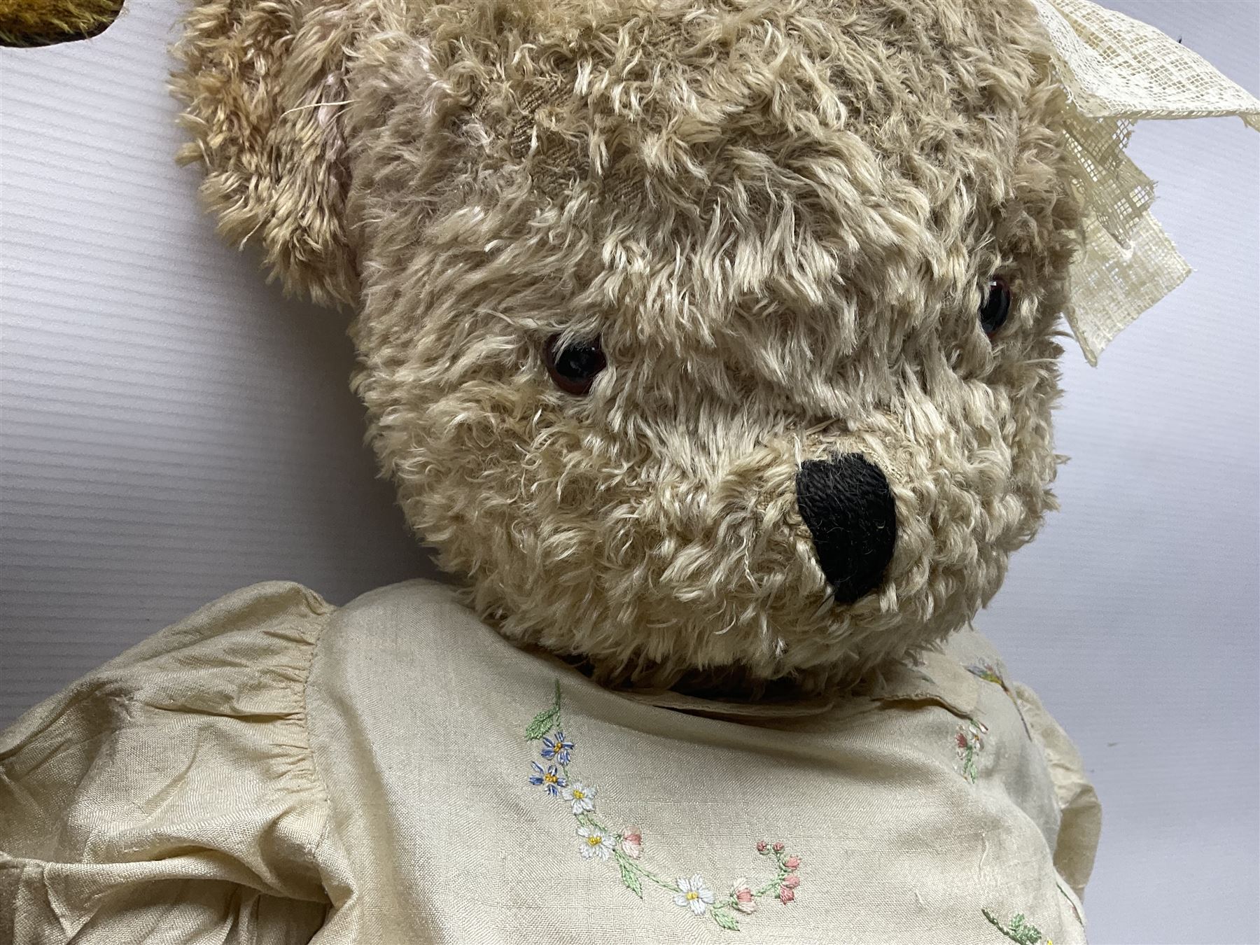 Two early 20th century straw filled jointed teddy bears, first example wearing a tweed jacket bearing Geoffrey Saville label, with leather padded paws and ears, horizontally stitched nose and humpback; second example with applied eyes, vertically stitched nose and faux leather paw pads, both with growler mechanisms, tallest H74cm 