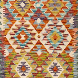 Chobi flatweave kilim runner with a repeating stepped diamond medallion design in live green, rust, teal, purple, and ivory, framed by chevron and geometric borders